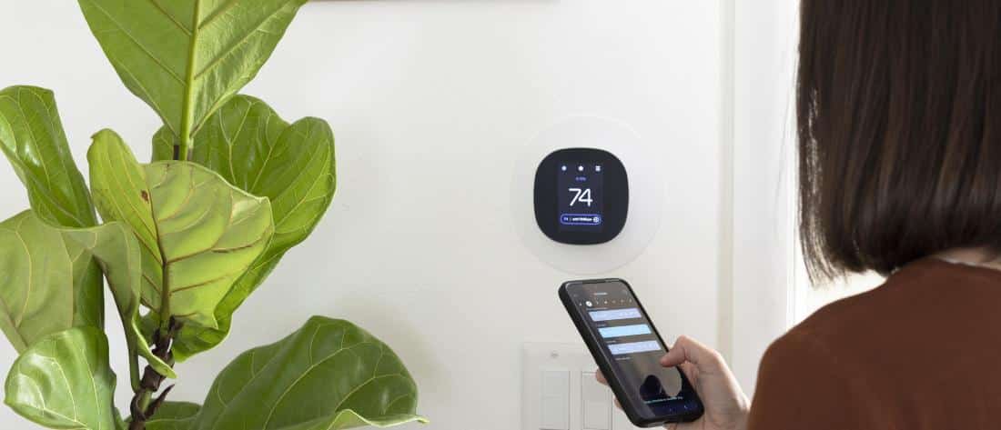 lady adjusting thermostat